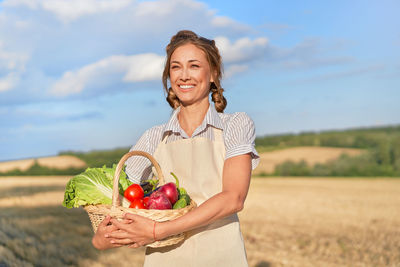Happy woman holding ice cream cone on land