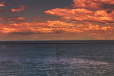 Scenic view of sea against cloudy sky at sunset