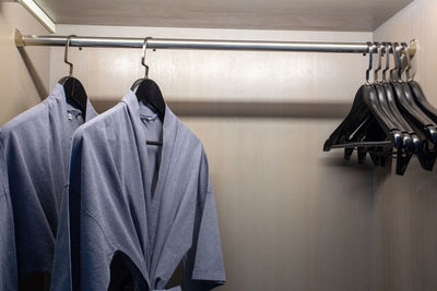 Close-up of clothes hanging on rack in shelf