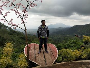 Full length of man standing on mountain against sky