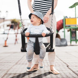 Low section of woman swinging at playground