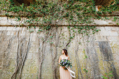 Woman standing by tree in forest