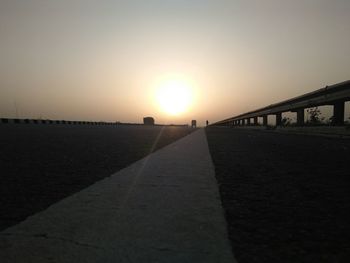 Bridge in city against clear sky during sunset