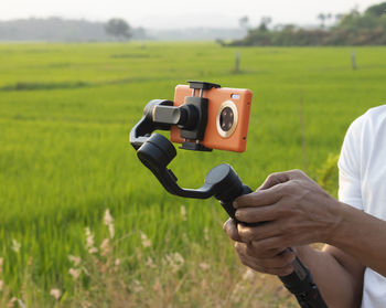 Man holding a gimbal with a phone in evenning