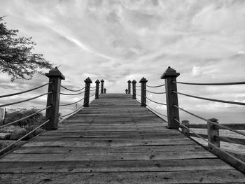 Pier over sea against cloudy sky