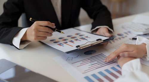 Midsection of business colleagues working at desk in office