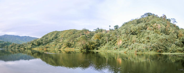 Scenic view of lake by trees against sky