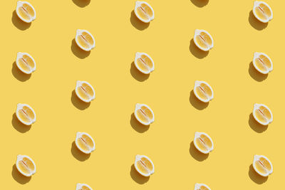 Conceptual pattern with halves of lemon collection with shadow on yellow background. healthy eating