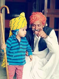 Grandfather and grandson wearing turbans at home