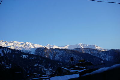 Scenic view of snowcapped mountains against clear blue sky