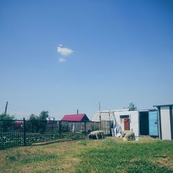 Built structure on grassy field against blue sky