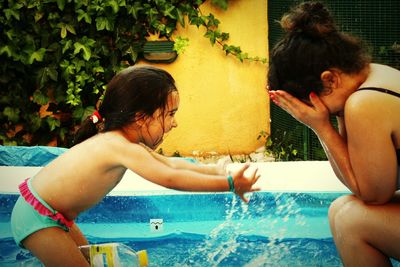 Siblings playing in swimming pool