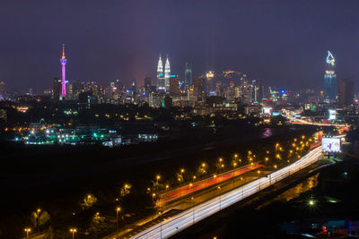 Illuminated cityscape against sky at night