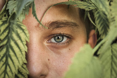 Close-up portrait of woman with green leaves