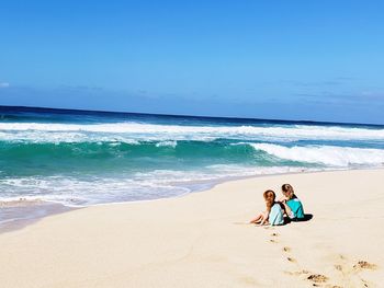 People on beach by sea against sky