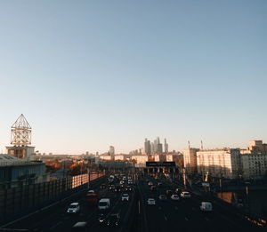 High angle view of traffic on road by buildings against clear sky