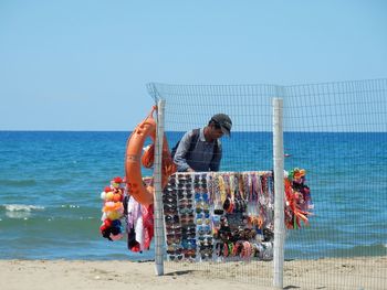 People on beach against clear sky