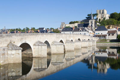 Arch bridge over river against clear sky