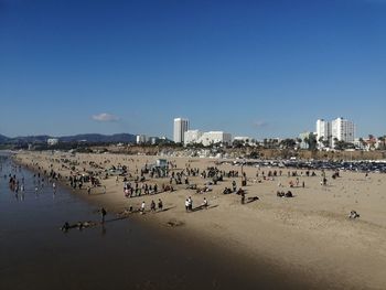 Group of people on beach against clear sky