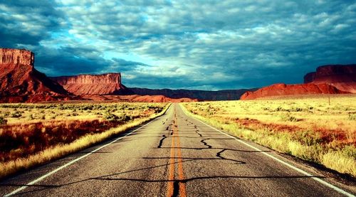 Country road against cloudy sky