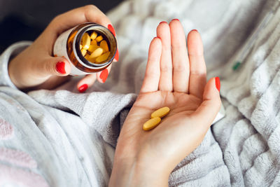 Close-up of woman holding hands on bed