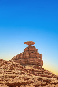 Low angle view of rock formations against clear blue sky