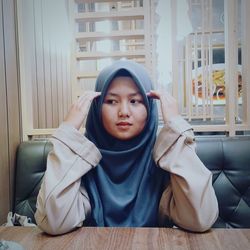 Young woman looking away while sitting at table