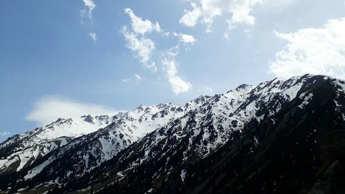 Low angle view of snowcapped mountains against sky