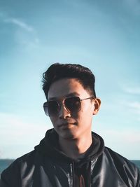 Portrait of young man wearing sunglasses against sky