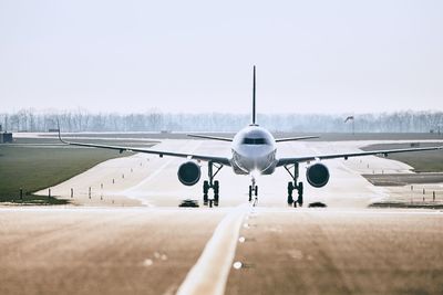 Airplane on runway against clear sky