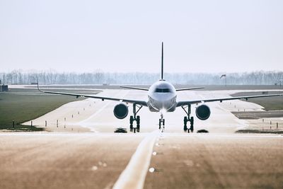 Airplane on runway against clear sky