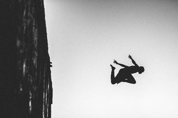 LOW ANGLE VIEW OF SILHOUETTE PERSON AGAINST SKY