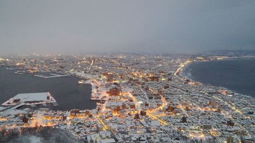 Aerial view of town by sea against clear sky