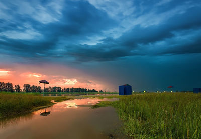 Scenic view of field against sky at sunset