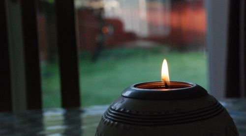 Close-up of illuminated candles on table against building