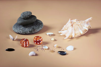 Background of sea stones, small shells and two amber dice