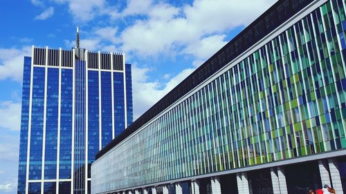 Low angle view of modern glass building against sky