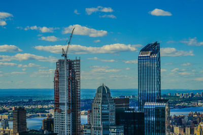 Modern buildings in city against cloudy sky