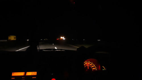 Illuminated street seen through car windshield at night