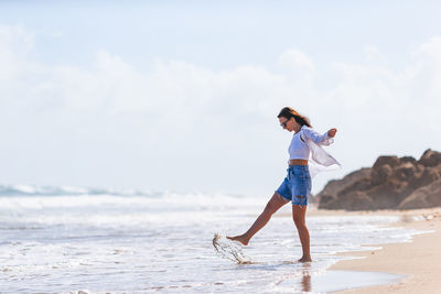 Side view of woman standing at beach