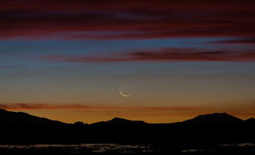 Scenic view of silhouette mountains against sky at sunset