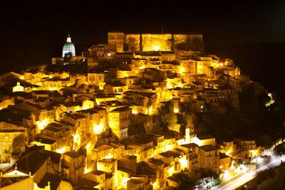 Illuminated city against sky at night