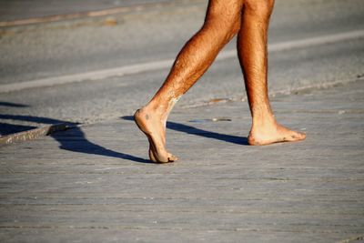 Low section of man walking on footpath