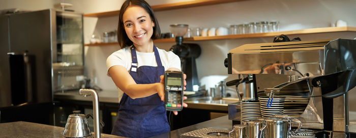 Portrait of young woman standing in cafe