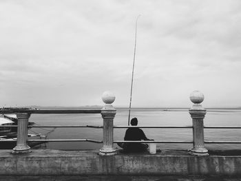 Man with umbrella against sky