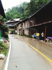 People walking on road along buildings