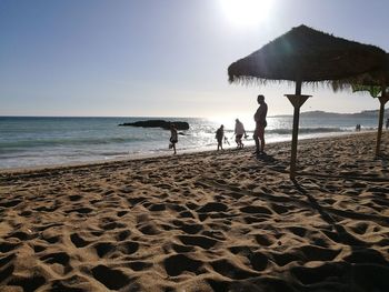 People on beach against clear sky