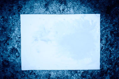 Directly above shot of ice on table against blue background