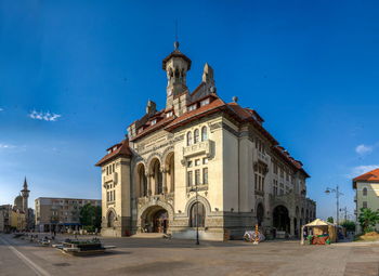 View of buildings against blue sky in city