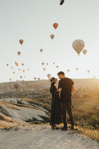 Full length of couple standing on landscape against clear sky